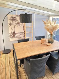 a dining room with a wooden table and chairs at Beleef Noordwijk strandhuisje in Noordwijk aan Zee