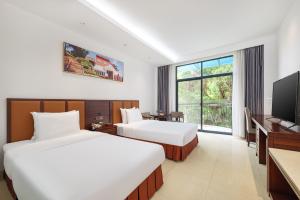 Xiamen Kulangsu Resort Hotel في شيامن: غرفة فندقية بسريرين وتلفزيون