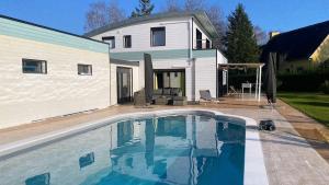 a swimming pool in front of a house at Maison Mélusine ossature bois forêt de Brocéliande in Néant-sur-Yvel