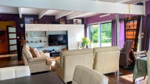 a living room with white chairs and a television at Maison Mélusine ossature bois forêt de Brocéliande in Néant-sur-Yvel