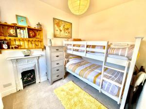 una camera con letto a castello e camino di Lovely Two Bed Cottage in North Kendal a Kendal