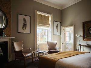 a bedroom with a bed and two chairs and a table at The Queensberry Hotel in Bath +114 photos