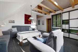 ヴァンガーラントにあるFerienwohnung Mit Terrasse, 70qmのソファと椅子とテーブルのあるリビングルーム