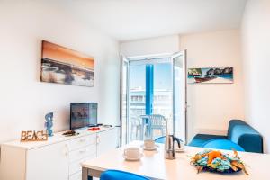 een woonkamer met een tafel en blauwe stoelen bij Condominio Athena in Bibione