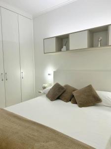 a white bedroom with a white bed with three pillows at B&B Le Chic in SantʼAntonio Abate