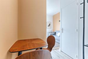 a room with a wooden table and two chairs at Mykeypers - Studio Cozy 2P - Malakoff 11 in Malakoff