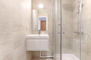 a white bathroom with a sink and a shower at Mykeypers - Studio Cozy 2P - Malakoff 11 in Malakoff