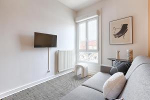 a living room with a couch and a tv at Mykeypers - Studio Cozy 2P - Malakoff 11 in Malakoff