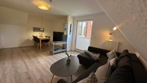 a living room with a couch and a table at Dünenhus Borkum in Borkum