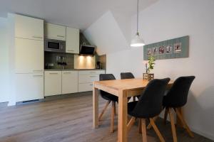 a kitchen and dining room with a wooden table and chairs at Dünenhus Borkum in Borkum