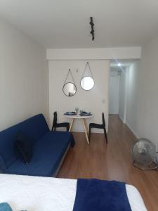 a living room with a blue couch and a table at Loft Blue - Av Rio Branco in Juiz de Fora