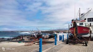 two boats are docked at a dock on the beach at Casa Velalatina in La Santa