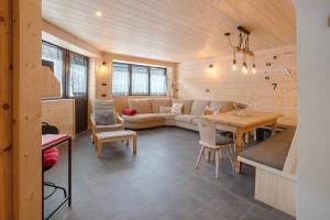 a living room with a couch and a table at Appartamenti I Portici in Santa Caterina Valfurva
