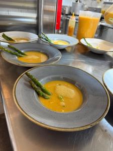 a bowl of soup with asparagus on a counter at Hotel Restaurant Brinckwirth in Ochtrup