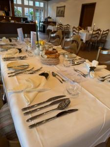 a table with silverware on a white table cloth at Hotel Restaurant Brinckwirth in Ochtrup