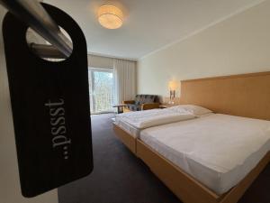 a hotel room with a bed and a chair at Hotel Restaurant Brinckwirth in Ochtrup