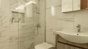 a bathroom with a toilet and a sink and a shower at Spiros House in Roda +34 photos