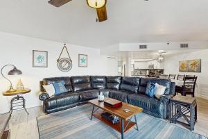 a living room with a leather couch and a table at Reef Club 107 in Clearwater Beach