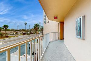 a building with a balcony next to a street at Reef Club 107 in Clearwater Beach