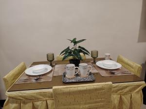 a wooden table with plates and utensils on it at Cozy Bella in Jalajala