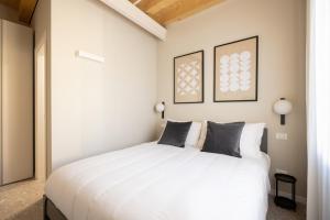Un dormitorio con una gran cama blanca con dos almohadas. en PALAZZO CIVIDALE Suite in the City Center, en Vicenza 3 fotos más