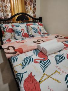 a bed with a bedspread with birds on it at Cozy Bella in Jalajala