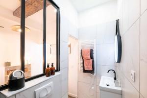 a white bathroom with a sink and a mirror at Saint Tropez - Old Village - Modern & Cosy Apartments in Saint-Tropez +18 photos