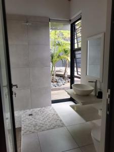 Un baño con lavabo, inodoro y espejo. en 69 Lagoon House, en Marina Beach 21 fotos más