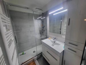 une salle de bain blanche avec lavabo et douche dans l'établissement Appartement à Cauterets avec parking privé et coin montagne - FR-1-812-34, à Cauterets