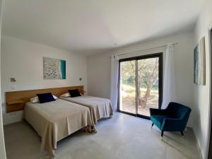 a bedroom with two beds and a chair and a window at Domaine Villas Celia in Monticello +184 photos