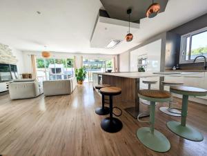 a kitchen with a counter and some stools at Villa plein Sud, clim et piscine, 6 à 8 personnes in Boisseron