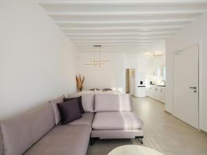 a white living room with a couch and a table at Sunset Windmills House in Mikonos