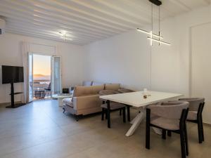 a living room with a table and chairs and a couch at Sunset Windmills House in Mikonos