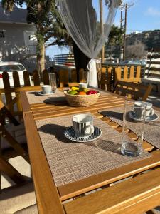 a wooden table with a bowl of fruit on it at Mika's Paradise in Archangelos