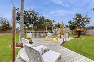 a wooden deck with chairs and a playground at Poolside Palms Paradise in Navarre