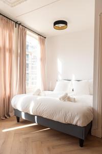 a bed in a bedroom with a large window at Historic Canal House Apartment in Amsterdam