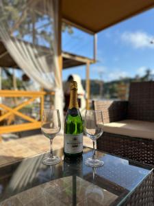 a bottle of wine and two wine glasses on a table at Mika's Paradise in Archangelos
