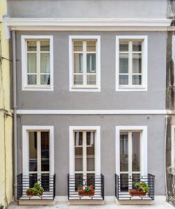 una casa gris con ventanas blancas y macetas en Casa Marina Guesthouse Cagliari, en Cagliari