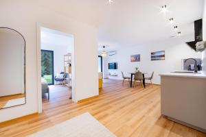 a kitchen and living room with white walls and wooden floors at NATURNEST Eifel in Daun