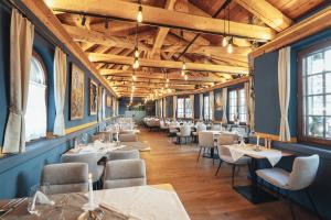 a dining room with tables and chairs and wooden ceilings at Zermatt Budget Rooms at Alpen Resort, Spa & Dining in Zermatt