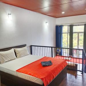 a bedroom with a bed with an orange blanket at Green View Ella in Ella