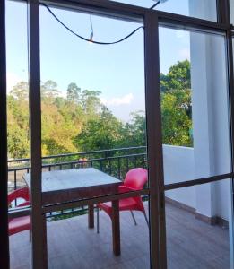 a balcony with a table and chairs on a balcony at Green View Ella in Ella
