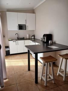 a kitchen with a black table and two stools at The Starling Room in East London