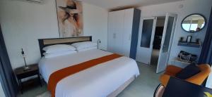 ein Schlafzimmer mit einem großen Bett mit einem Gemälde an der Wand in der Unterkunft 511 Umdloti Resort 1 bed beachfront Self catering Apartment Wow sea View in Umdloti + 49 Fotos