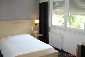 Postel nebo postele na pokoji v ubytování Hôtel Restaurant La Charrue
