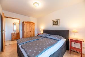 a bedroom with a large bed and a wooden floor at Ferienhof Bruhn "Nr 2" in Midlum