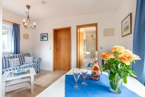a living room with a table with a vase of flowers at Ferienhof Bruhn "Nr 3" in Midlum +7 photos