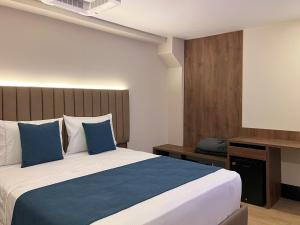 ボゴタにあるHotel Continental ByHoursの青い枕が付いた大きなベッドのある寝室