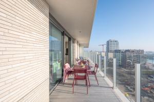 a table and chairs on the balcony of a building at Sixt Haven, panoramisch appartement Oosteroever, Oostende in Ostend