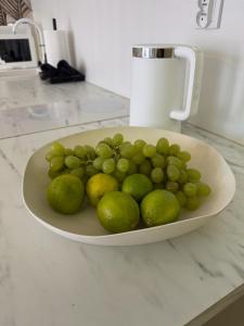 a plate of green grapes and limes on a counter at Apartament Pod Żaglami 1 in Sława